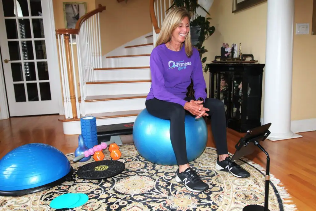 Marilyn Moss leads a personal training session on Zoom wearing a shirt that says Functional Fitness Guru.